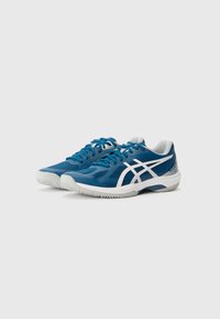 Baskets de sport bleues avec matériau en mesh, accents blancs, semelle texturée et design profil bas avec lacets et col rembourré.