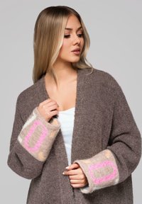 Cardigan marrone lavorato a maglia con ampie maniche decorate da motivi rosa, arancioni e crema. Tessuto morbido e design a apertura frontale.
