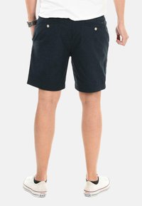 Dark navy shorts made of cotton blend, featuring two back pockets with button accents and a straight cut finishing above the knees.