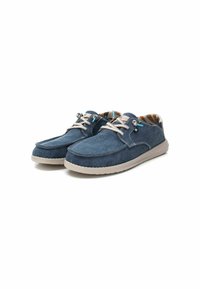 Zapatos de lona azules con acentos beige, que cuentan con una suela de goma, costuras tonales y terminaciones azules en los cordones. El interior tiene un patrón a rayas.