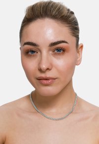 Zilveren ketting met een gedraaide ontwerp, met een gladde, gepolijste afwerking. Ggedragen tegen blote huid met minimale afleidingen.