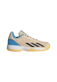 Zapatilla deportiva color beige con parte superior de malla, acentos en azul, rayas negras y suela de goma amarilla. Diseñada para ofrecer comodidad y apoyo durante la actividad.