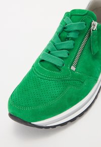 Baskets en daim vert vif avec lacets assortis, fermeture éclair latérale, zone des orteils perforée et semelle en caoutchouc blanche et noire.