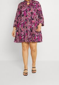 Vestido de línea A de manga corta en negro con un vibrante patrón de paisley rosa, que presenta un detalle de escote con abertura y una longitud por encima de la rodilla.