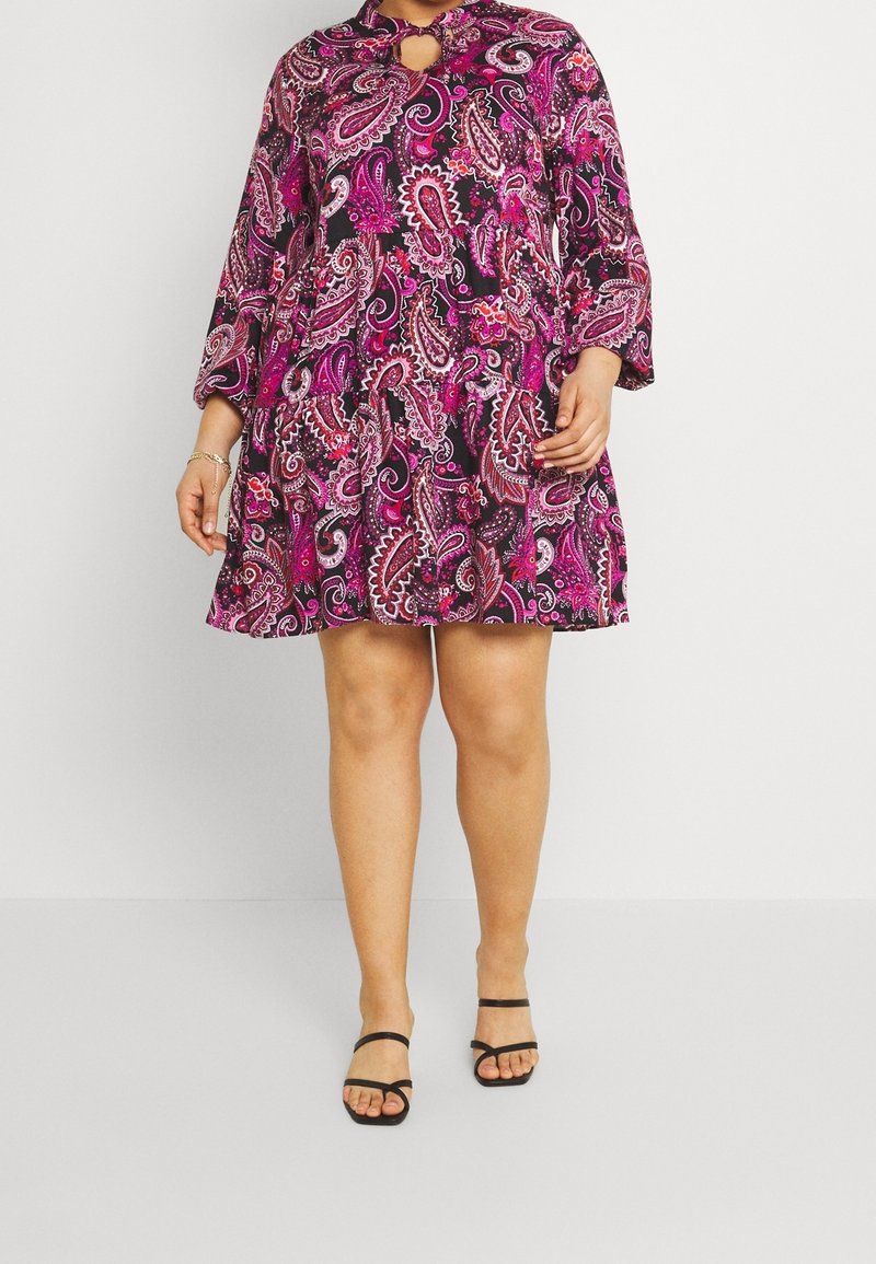 Vestido de línea A de manga corta en negro con un vibrante patrón de paisley rosa, que presenta un detalle de escote con abertura y una longitud por encima de la rodilla.