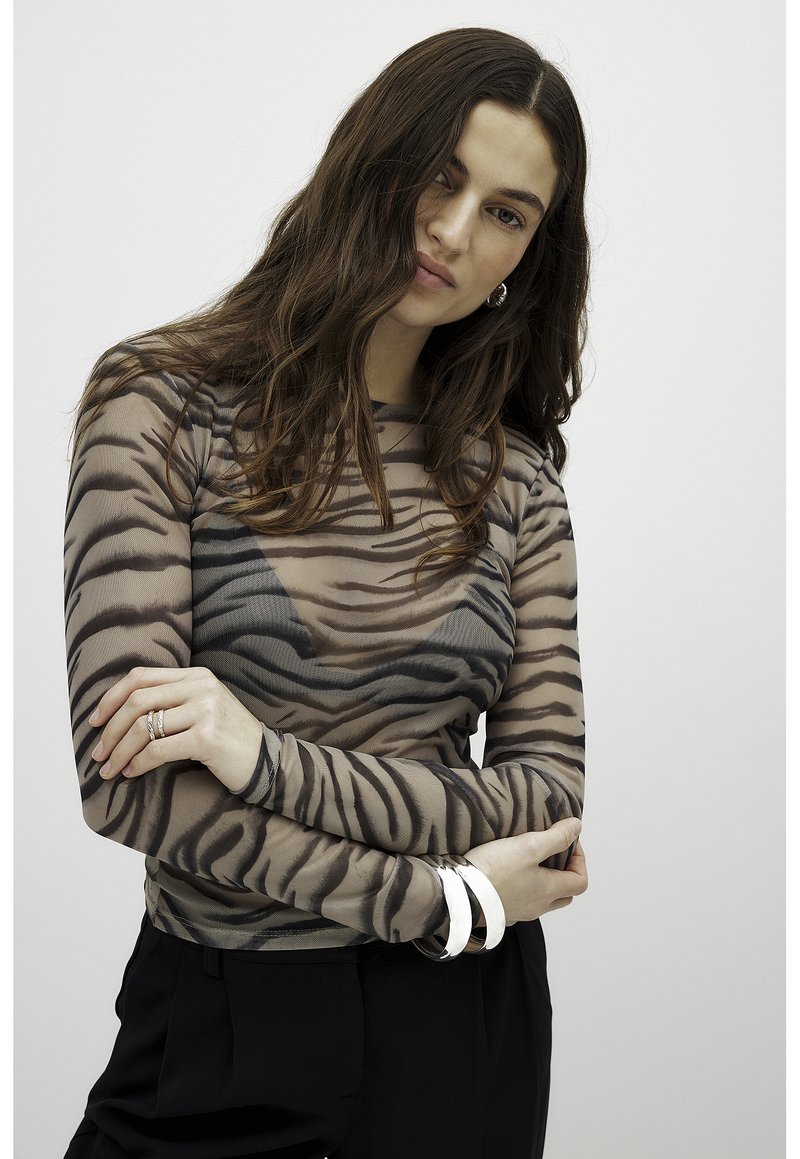 Long-sleeve sheer top with a tiger stripe pattern, made of lightweight material. Features a fitted silhouette and round neckline.
