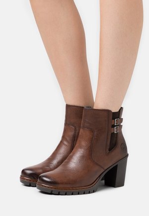 Bottes en cuir marron à la cheville avec une finition texturée, dotées de deux boucles latérales, d'un talon épais et d'une semelle robuste.