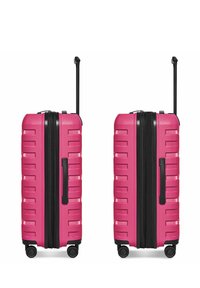 Deux valises rigides roses identiques, équipées de quatre roues et de poignées noires déployées, posées côte à côte sur un fond blanc.