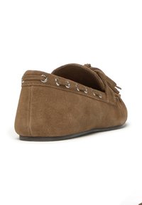 Mocasin de ante marrón con tacón plano, que presenta ojales plateados a lo largo del borde y detalles de flecos en la parte frontal. Textura suave y forma redondeada.