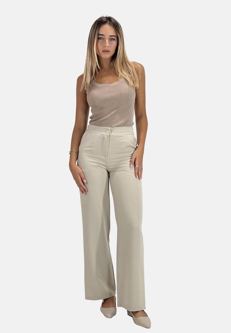 Ljus beige ribbad linne i kombination med högmidjade vida byxor i ett mjukt tyg, med knäppning fram och fickor.