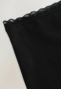 Melns audums ar gludu tekstūru un virsū viļņotu mežģīņu apdari. Kopējais forma ir taisnstūrveida.