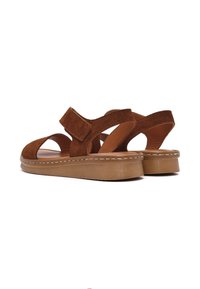 Bruine suède sandalen met een gesloten hiel, open teen en verstelbare klittenbandsluiting. Gecodeerde zool met een contrasterende lichte stikseldetail.