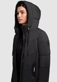 Crni puffer jakna s patentnim zatvaračem sprijeda, velikim kapuljačom i kviltanom teksturom. Ima podesive vrvice i bočni džep s metalnim detaljima.