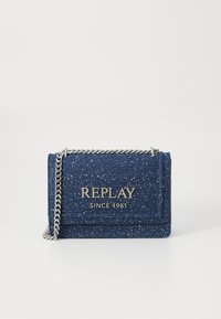 Tumši zils punktains auduma plecu soma ar sudraba ķēdes siksnu un metalizētu "REPLAY SINCE 1981" logo priekšējā atlokā.