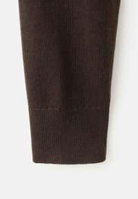 Braunes Strickärmelsaum mit geripptem Muster, sauber verarbeitet ohne sichtbare Beschläge oder Verzierungen.