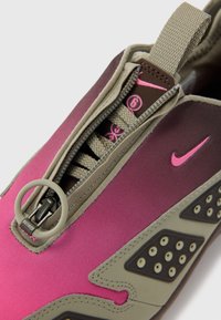 Nike-sko med gradientdesign i rosa og brunt, med glidelås, teksturerte detaljer og en løkke for enkel håndtering.