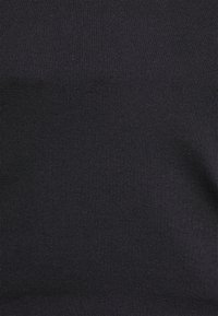 Svart ribbat tyg med en slät yta, med ett konsekvent mönster och en elastisk design som är lämplig för olika användningar.