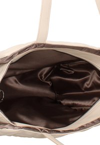 Borsa a mano beige con esterno strutturato, dotata di un ampio interno in raso marrone e di una tasca con cerniera. Include due manici robusti.