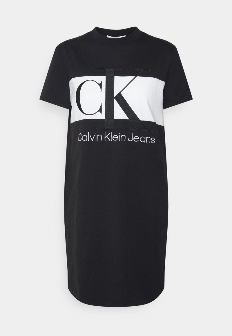 Czarna bawełniana sukienka t-shirtowa z krótkimi rękawami, z białą prostokątną wstawką oraz wyboldowanym czarnym logo "CK" z napisem "Calvin Klein Jeans" poniżej.