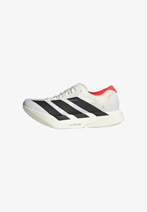 Chaussure de sport blanche avec des rayures diagonales noires, des accents rouges au talon et une tige texturée ; elle est dotée d'un amorti LIGHTSTRIKE PRO.