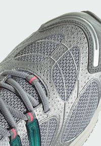 Sive tenisice za sport s mrežastim gornjim dijelom s teksturiranim uzorcima, roza akcentima, reflektirajućim detaljima i sustavom vezivanja s tirkiznim umetak.