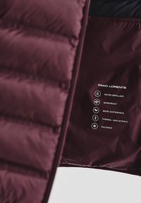 Bordowa kurtka ocieplana o błyszczącej fakturze, charakteryzująca się właściwościami wodoodpornymi i wiatroszczelnymi, oraz możliwością spakowania. Zawiera symbole pielęgnacyjne.