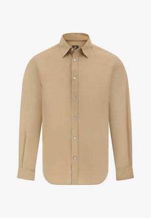 Beige pitkähihaista nappikauluspaitaa, joka on valmistettu sileästä kankaasta. Paidassa on klassinen kaulus, etunappilista ja pyöristetyt helmalle.