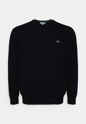 Pull noir à manches longues avec col rond et petit logo crocodile vert Lacoste sur la poitrine gauche.