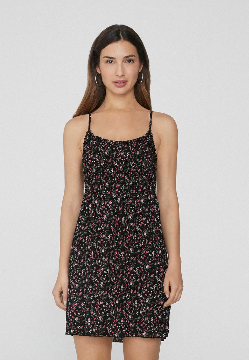 Schwarzes Blumen kleid mit dünnen Trägern, einem figurbetonten Oberteil und einem ausgestellten Rock. Der Stoff hat ein kleines Rosenmuster und eine leichte Textur.
