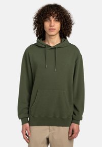 Grøn bomulds hoodie med en kængurulomme, justerbar snor i hætten, ribbede manchetter og en subtil logo detalje på brystet.
