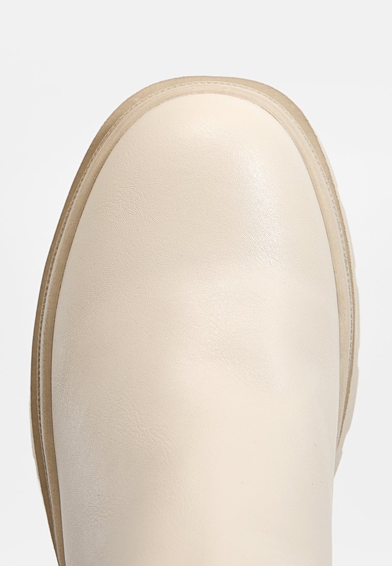 Cremfarbene Leder-Stiefelette mit runder Zehenform, glatter Textur und leichtem Glanz. Verfügt über eine kontrastierende helle Sohle und ein minimalistisches Design.