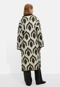 Long, open-front coat featuring an abstract leaf pattern in dark green on a light gray background. Fabric appears soft and textured.