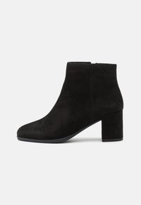 Schwarze Wildleder-Ankle Boots mit runder Zehenpartie und Blockabsatz in mittlerer Höhe, ausgestattet mit einer glatten Textur und einem seitlichen Reißverschluss für einfaches An- und Ausziehen.