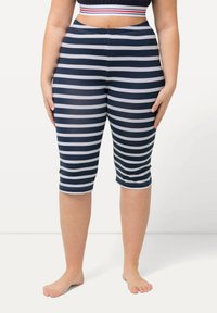 Tmavě modré a bílé pruhované capri legíny s elastickým pasem, přiléhavým střihem a hladkou texturou, končící těsně pod kolenem.