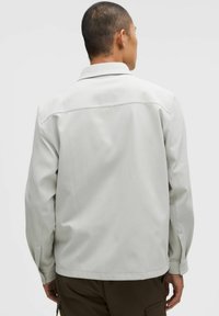 Hea hall jakk, millel on kaelus, pikad varrukad ja sile tekstuur. Omab minimaalset õmblust ja lõdva istuvust.