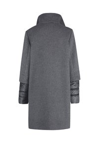 Šedý kostkovaný kabát s vysokým límcem, plnými rukávy z černého polstrovaného materiálu. Rovný silueta, texturovaná tkanina, bez viditelných zapínání.