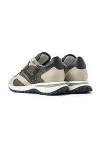 Beige und schwarze Sneaker aus Mesh- und Leder-Materialien, mit einer strukturierten Ferse, kontrastierenden Streifen und einer weißen Sohle mit strukturiertem Profil.