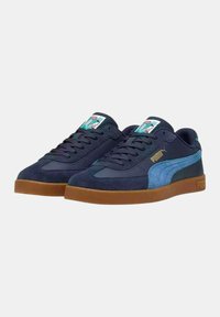 Zapatillas de deporte azul marino con parte superior de ante y textil, con un acento lateral azul claro, suela de goma y logo en la lengüeta y el lateral.