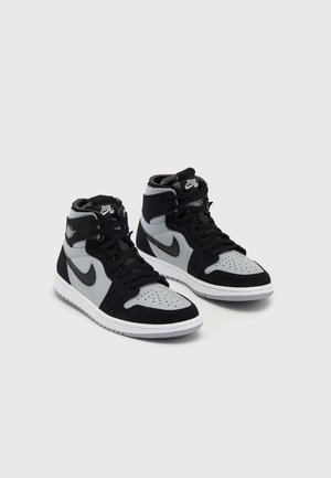 Paar schwarze und graue Nike High-Top-Sneaker mit weißen Sohlen, sichtbarem Nike-Swoosh und „Zoom Air“-Branding auf der Zunge.