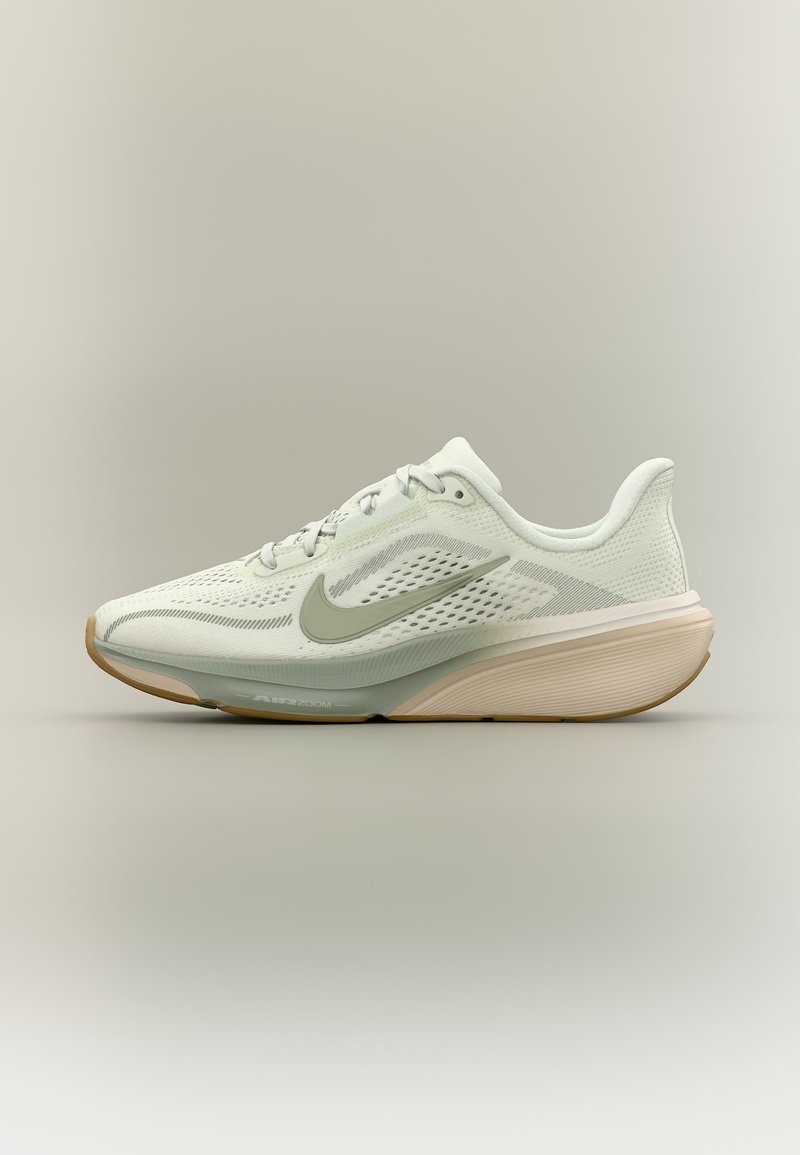 Chaussure de course Nike blanche et beige avec tige en mesh, fermeture à lacets et semelle rembourrée sur un fond neutre uni.
