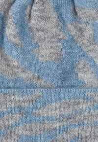 Beanie lavorato a maglia grigio e azzurro chiaro con una texture morbida, caratterizzato da un motivo a spirale e un risvolto piegato nella parte inferiore.