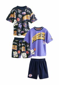 Två uppsättningar barnens sportkläder: en svart med färgglada basketgrafiker; en annan lila med gul text och marinblå shorts.