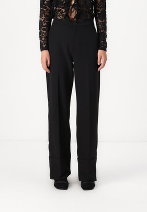 Pantalons larges noirs en tissu lisse, dotés d'une fermeture à bouton à l'avant et d'un pli le long de chaque jambe pour un look soigné.