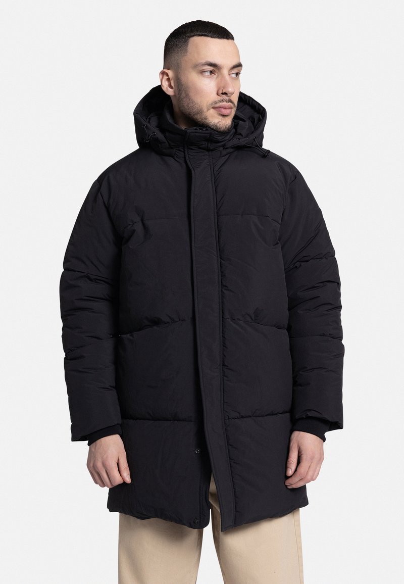 Abrigo acolchado negro con capucha, diseño de acolchado, cierre de botones y bolsillos. Hecho de un material suave y ligero, que ofrece aislamiento.