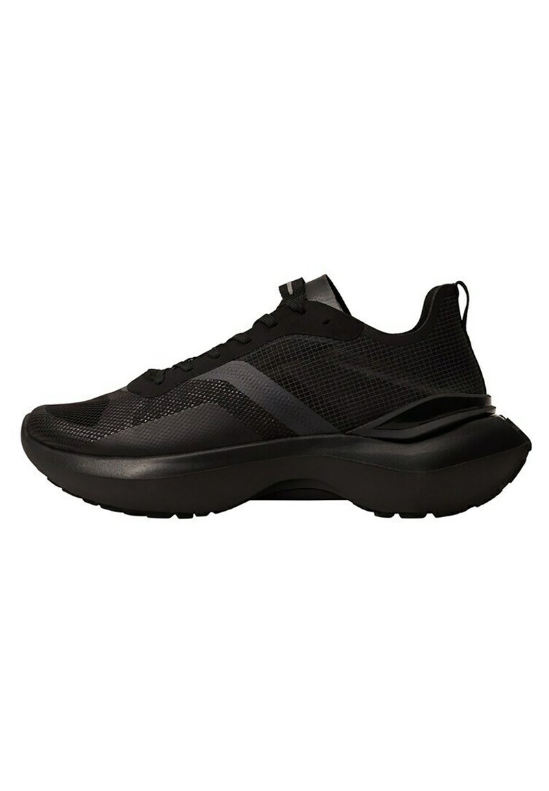 Chaussure de sport noire avec une tige en mesh, des accents texturés, une semelle arrondie et un talon rembourré. Dotée d'une fermeture à lacets et d'un profil élégant.