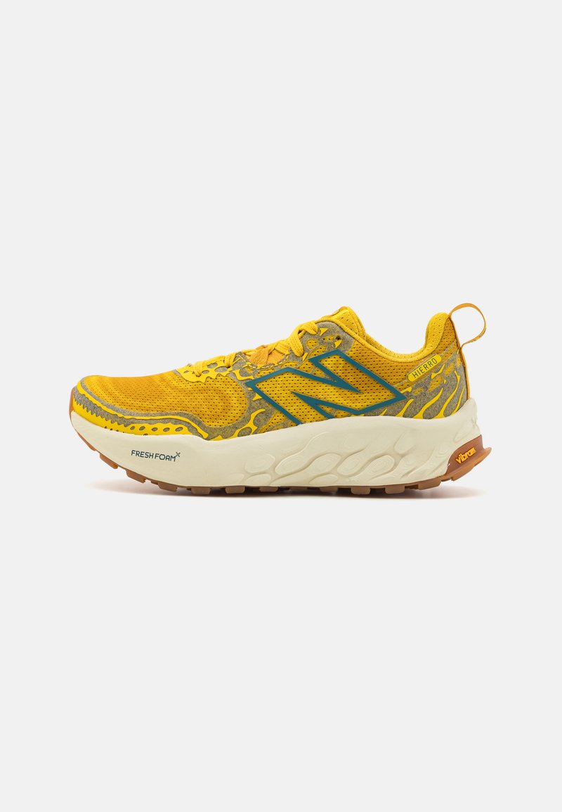 Scarpa da trail running di un brillante colore giallo con una tomaia in rete, sovrapposizioni sintetiche e una suola ammortizzata. Presenta una suola Vibram per una migliore aderenza.