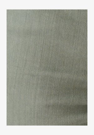 Tissu en denim vert clair avec une texture lisse et un motif discret en tissage diagonal. Matériau doux et flexible, idéal pour les vêtements.