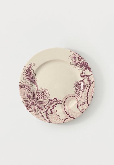 Assiette ronde en céramique crème avec des motifs floraux et paisley bordeaux décorant la moitié de son bord sur un fond blanc.