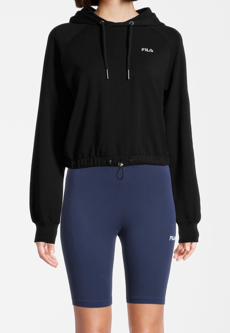 Sweat-shirt à capuche noir avec un design raccourci et un cordon de serrage, associé à un short de vélo bleu marine. Les deux présentent le logo FILA.