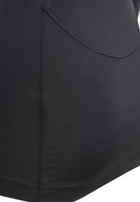 Haut ajusté noir en mélange de nylon lisse. Présente une couture courbée et une poche discrète, avec un design épuré et minimaliste.